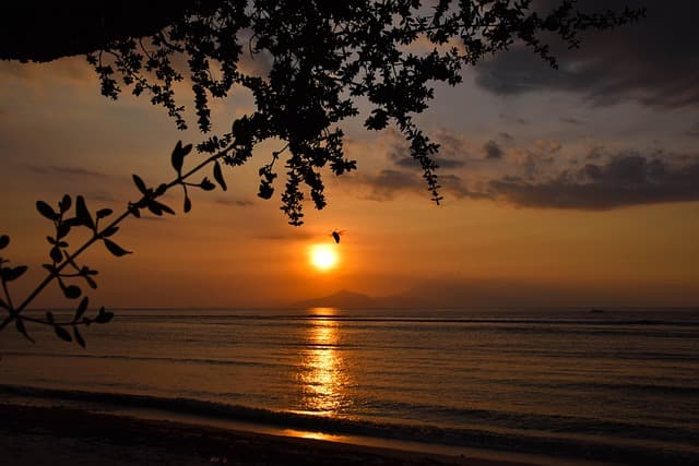 A traditional Balinese sea temple silhouetted against the sunset