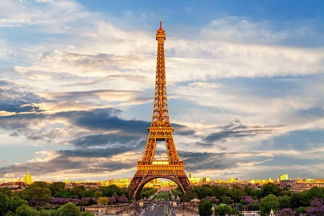 The Eiffel Tower rising above the rooftops of Paris at dusk